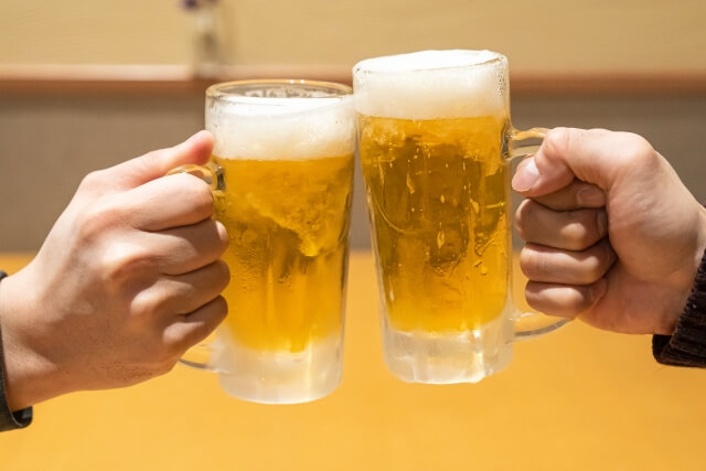 ビールジョッキで乾杯する二人の手